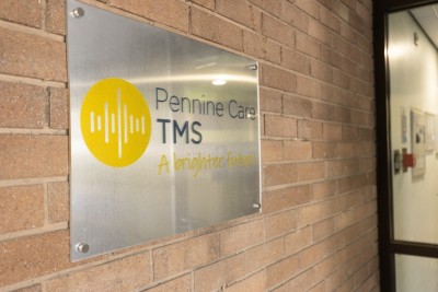 Pennine Care TMS signage on brick wall